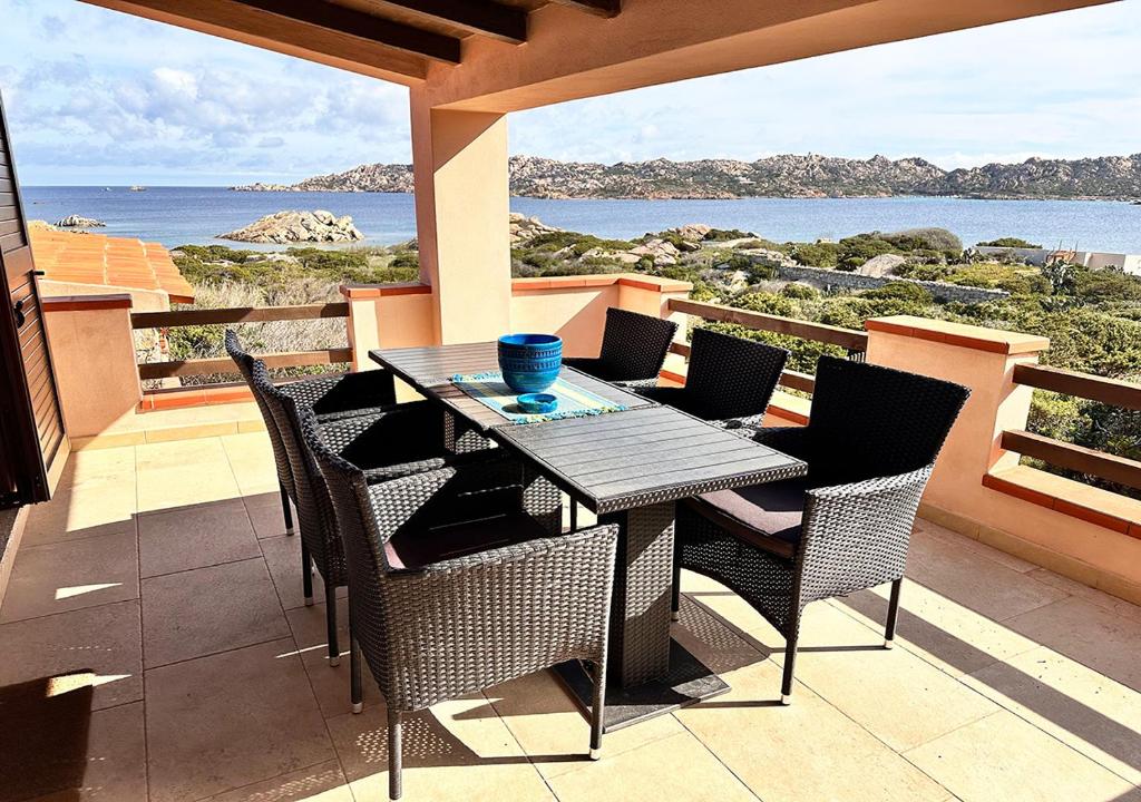 a table and chairs on a balcony with a view of the ocean at Villa Iole in Casale Azara