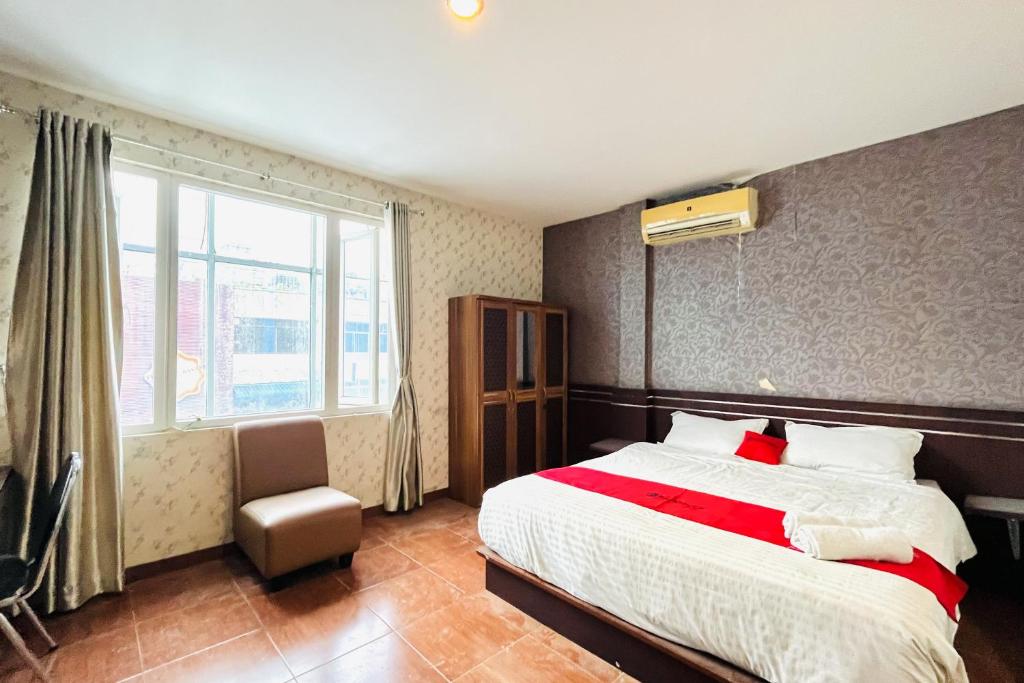 Un dormitorio con una cama grande y una ventana en RedDoorz @ Best Hotel Jalan Dr. Sutomo Siantar en Pematangsiantar