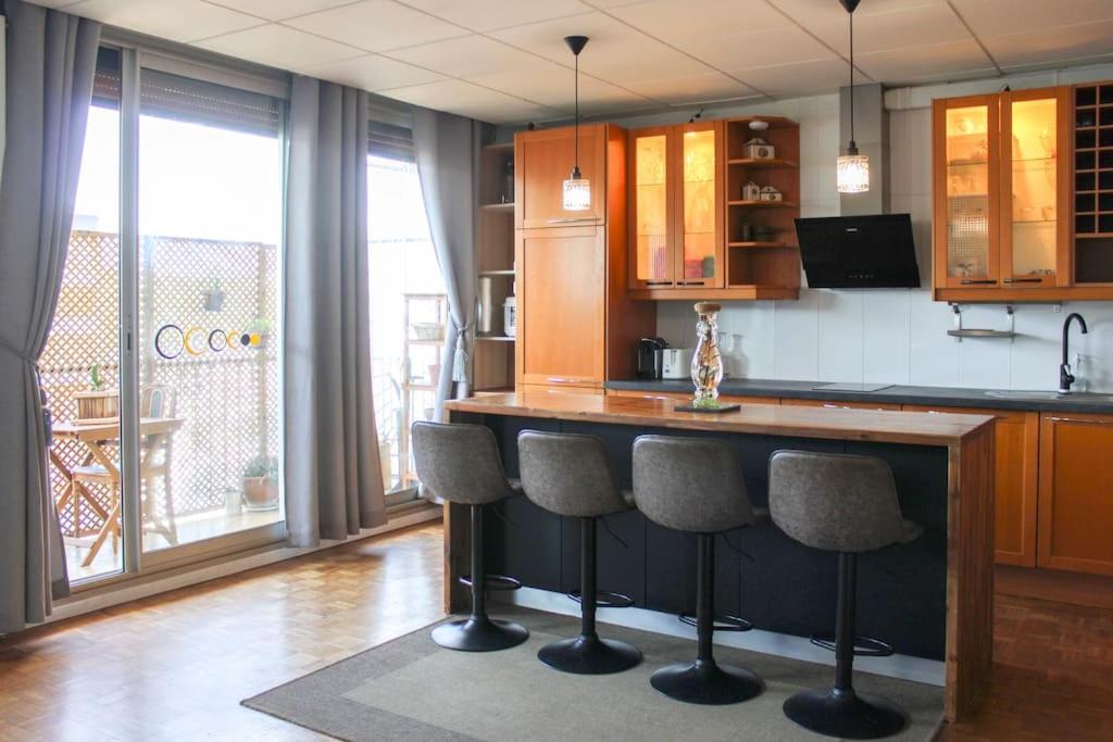 una cucina con bancone e sgabelli di Balcony, 2 Rooms, View of Eiffel Tower, 60m² a Boulogne-Billancourt