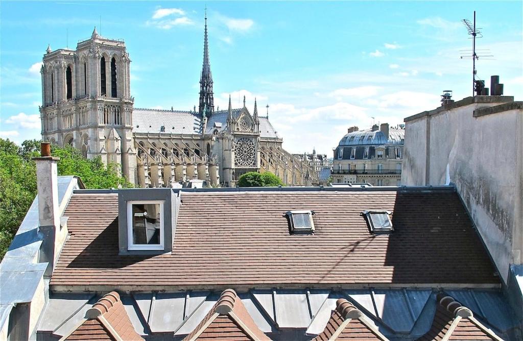 - une vue sur le toit d'un immeuble avec une cathédrale dans l'établissement A Balcony on Notre Dame, à Paris