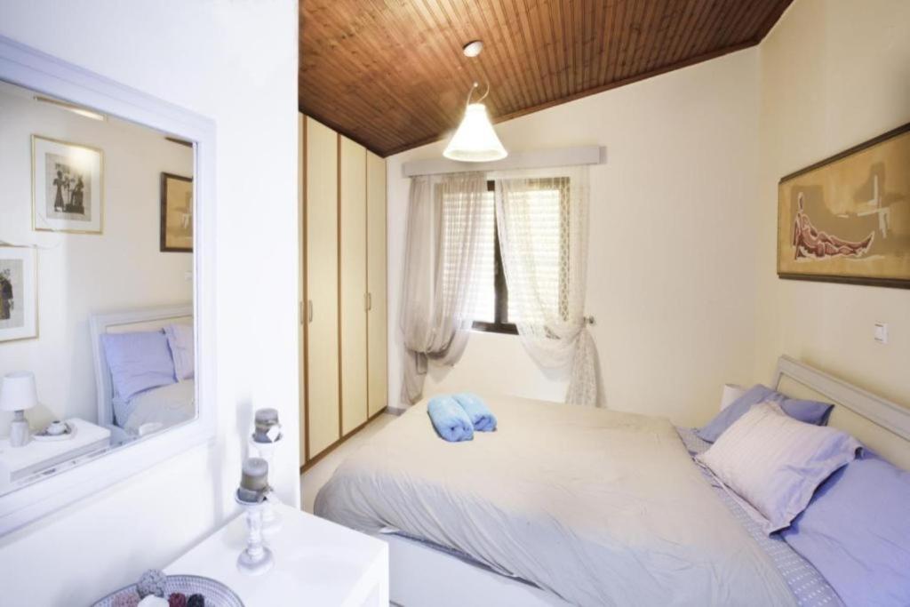 een slaapkamer met een bed, een spiegel en een wastafel bij Nelly's Private Resindence in Chania