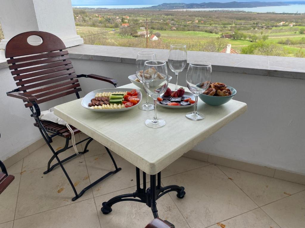 einen Tisch mit Weingläsern und eine Schüssel Essen in der Unterkunft Fishing & Golf Kisleshegy Balatonudvari Vendégház in Balatonudvari