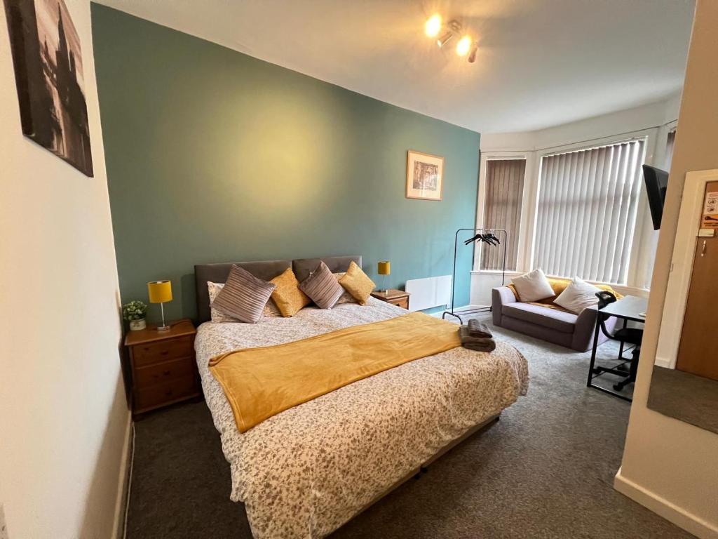 a bedroom with a large bed and a couch at Coventry station Deluxe studio in Coventry