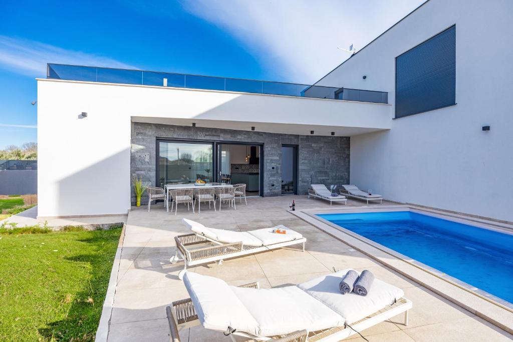 een patio met een zwembad en een huis bij Villa EnDi in Medulin