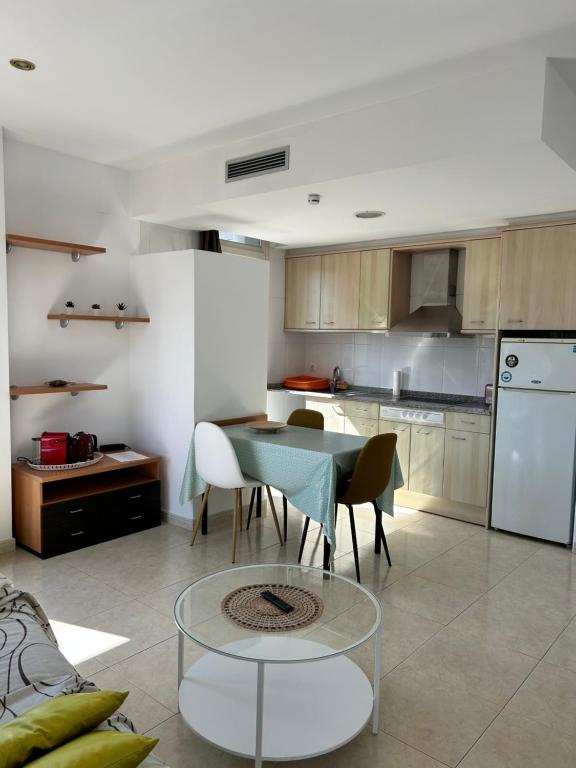 cocina con mesa, sillas y nevera en Apartaments Superiors MTB Only Couples en Lloret de Mar
