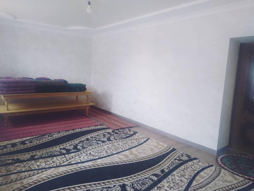 esquina de una habitación con un banco y una alfombra en Ak-Tal guesthouse, en Akkyya