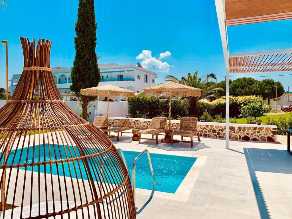 a bird cage sitting next to a swimming pool at Ferienhaus mit Privatpool für 6 Personen ca 105 m in Faliraki, Ägäis Rhodos in Faliraki