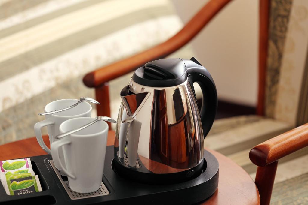 a tea kettle and two cups on a table at Amigo City Centre in Prague