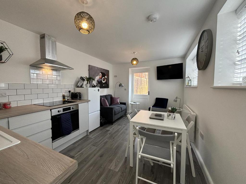 a kitchen and living room with a table and a dining room at Hartshorne House in Telford