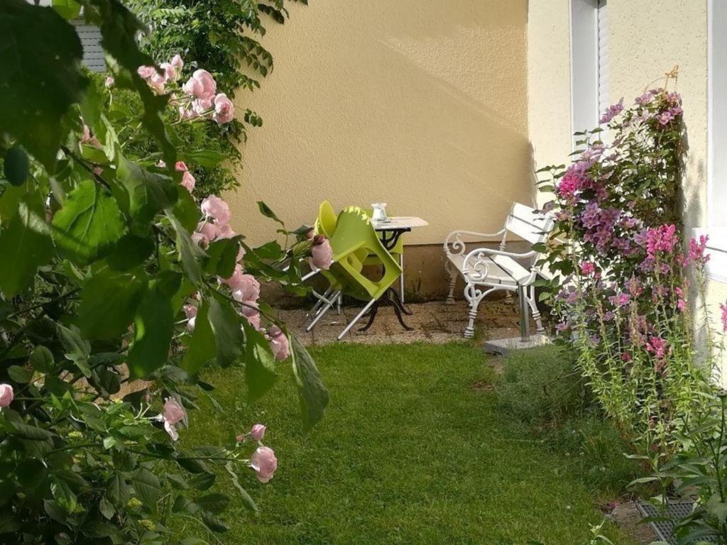 un jardín con mesa, sillas y flores en Ferienhaus in Trittenheim mit Privatem Garten en Trittenheim
