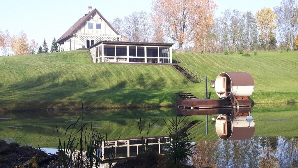 una casa en una colina junto a un cuerpo de agua en Põhjakalda, en Nüpli