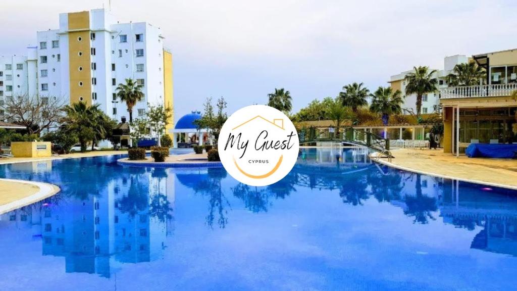 a swimming pool at a resort with a sign on it at MyGuest Cornelius 70 , 1-Bedroom Luxury Apartment in Iskele