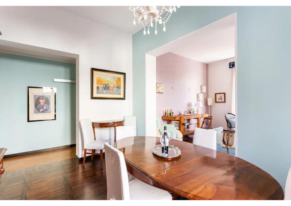 a dining room with a wooden table and white chairs at Villa Liberty TownHouse in Siena