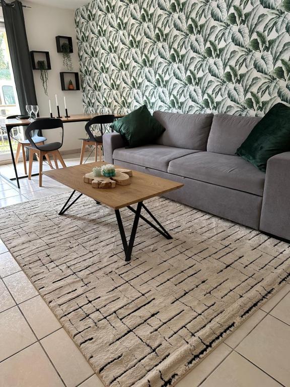 a living room with a couch and a coffee table at Appartement de Charles in Roye