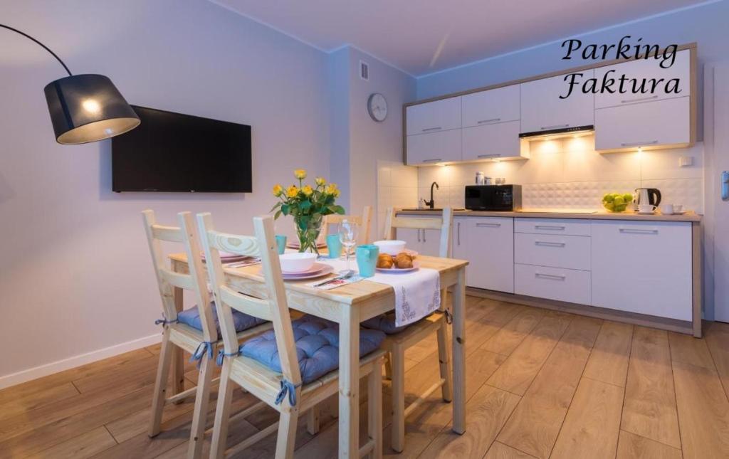 a kitchen with a table and chairs and a kitchen with a counter at Apartament Słoneczny in Ustrzyki Dolne