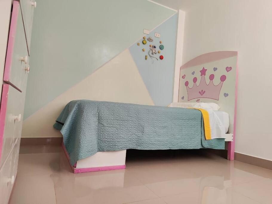 ein Kinderschlafzimmer mit einem Bett mit einer Krone darauf in der Unterkunft Departamento de tres dormitorios en Ica in Ica