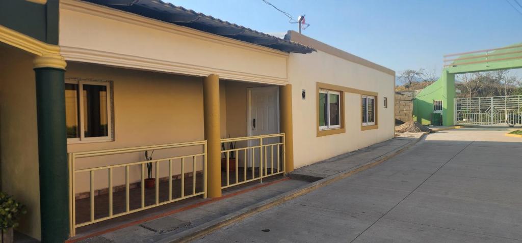 żółty budynek z żółtymi kolumnami i gankiem w obiekcie Loma Verde w mieście Danlí