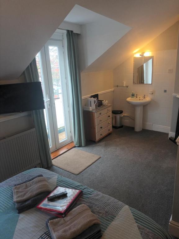 a bathroom with a bed and a sink in a room at The Beaches in Scarborough