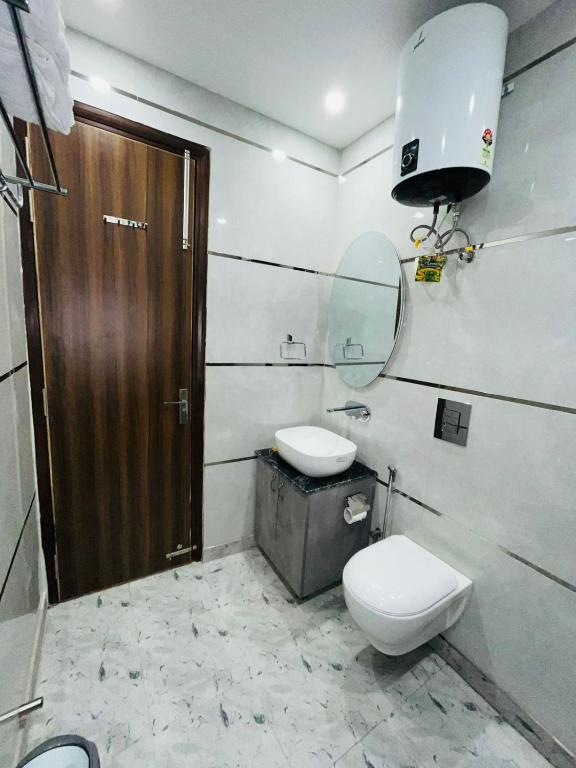 a bathroom with a toilet and a sink and a mirror at Hotel in New Delhi