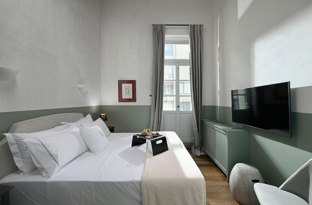 1 dormitorio con 1 cama blanca y TV en Beautiful Athens Apartment | 1 Bedroom | Apartment Gildarts | Furnished Balcony Overlooking the City | Athinaidos en Athens