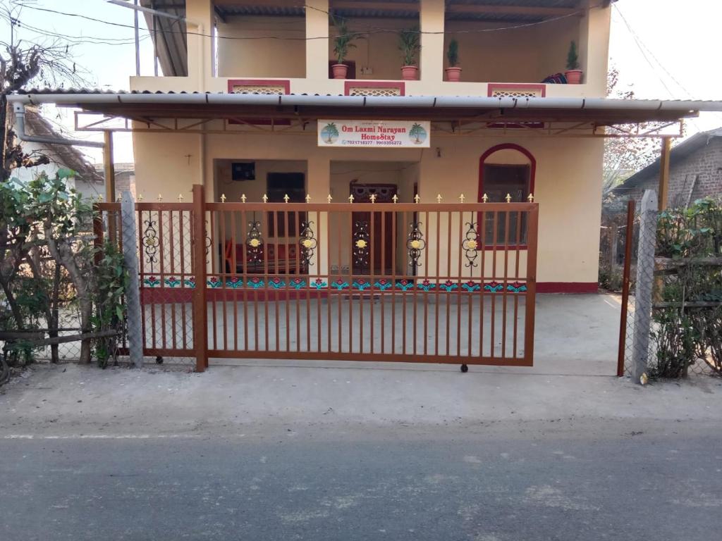 una puerta frente a una casa con un edificio en Om Laxmi Narayan Homestay, en Diveagar