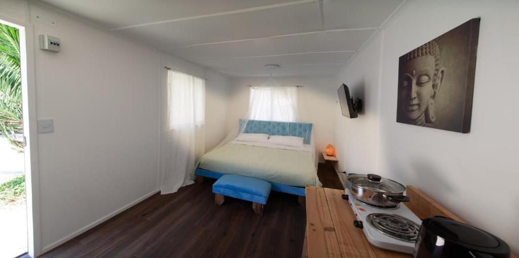 een kleine slaapkamer met een bed en een raam bij Alme cabañas Olmué in Granizo