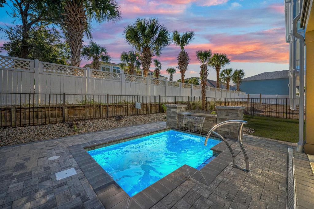 a swimming pool in a yard with a fence at North Myrtle Beach Home - Walk to the Ocean! in Myrtle Beach