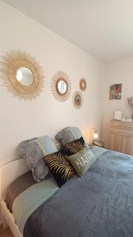 a bedroom with a bed with two mirrors on the wall at Chambres d&#39;hôtes &amp; jacuzzi - A l&#39;ombre des amandiers in Saint-Martin-dʼArdèche