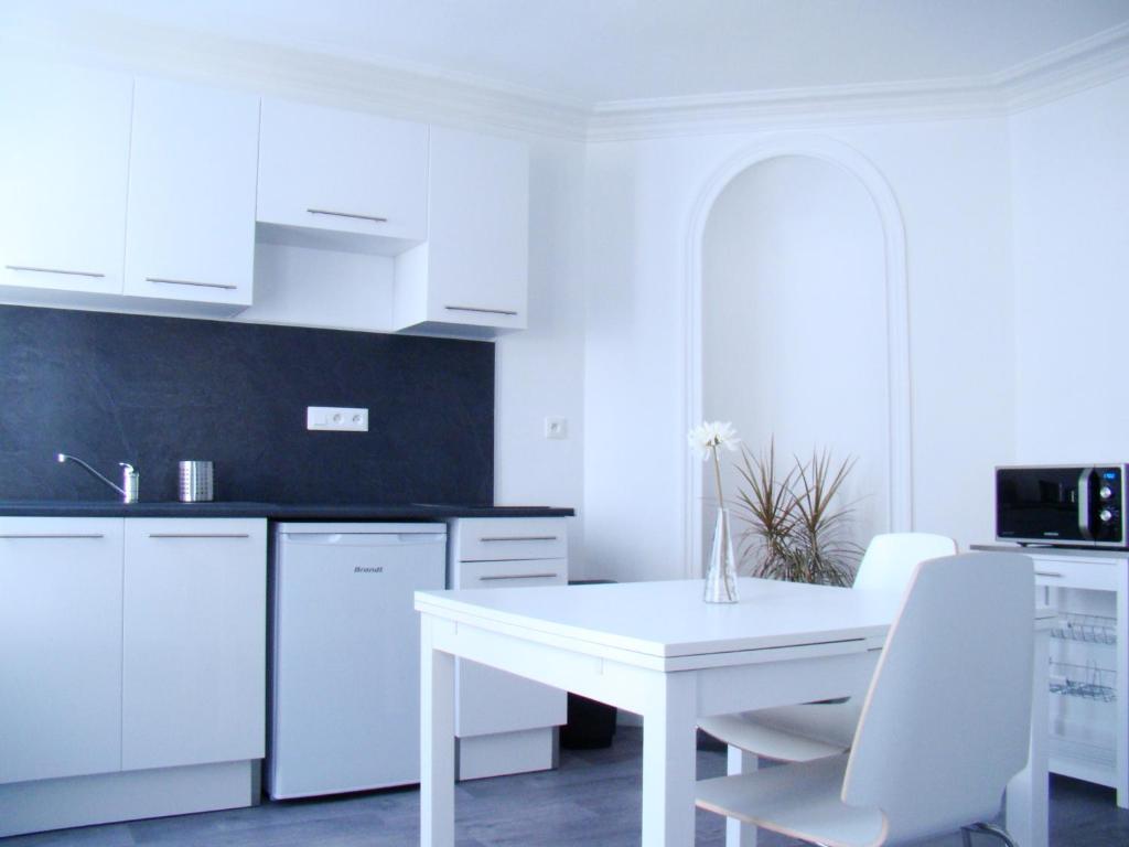 トロワにあるBel Appartement Coeur de Villeの白いキッチン(白いテーブル、白い椅子付)