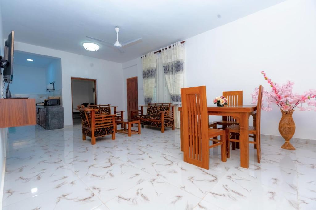 a dining room and living room with a table and chairs at The Islands Breeze Villa in Dehiwala