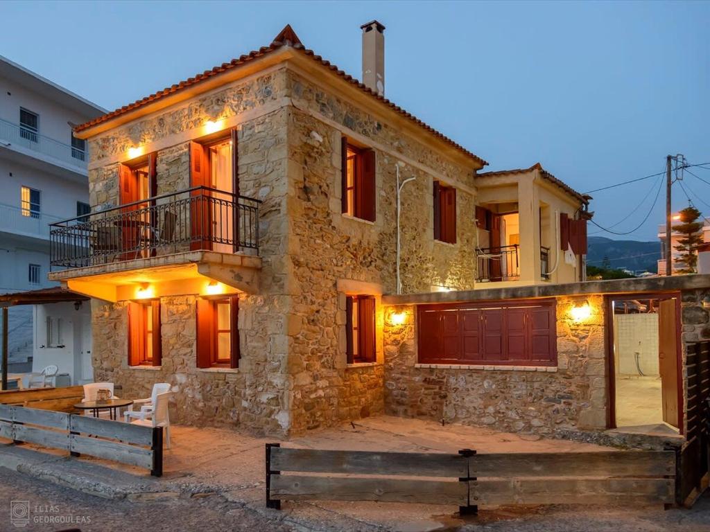 Casa de piedra con balcón en una calle en Waveside Sanctuary - Luxurious Seastone Villa, en Avía