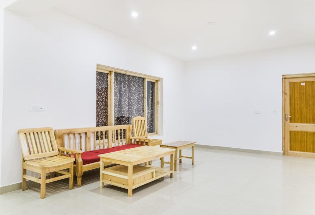 Cette chambre dispose d'un mobilier en bois, d'une table et de chaises. dans l'établissement OYO Deluxe United Corporate Home, à Airoli