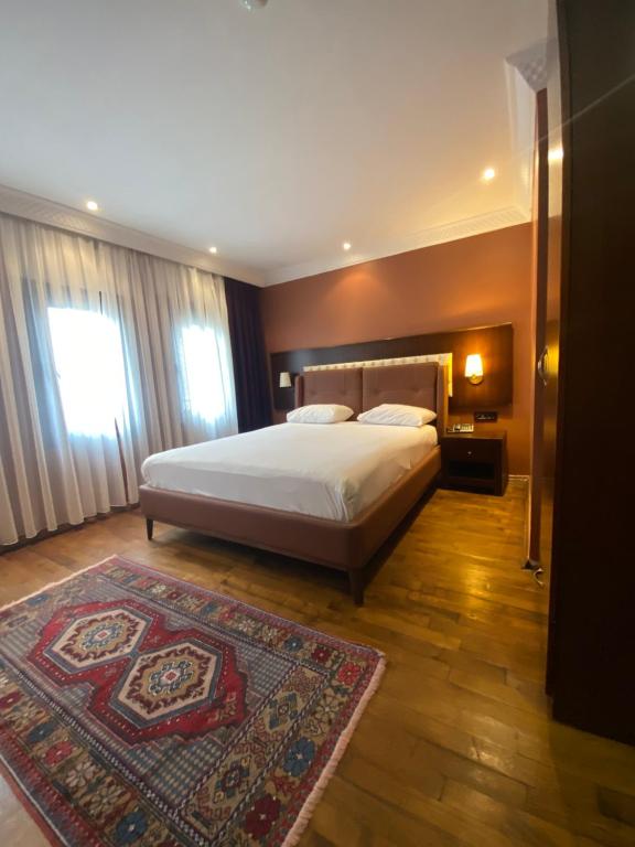 a bedroom with a large bed and a rug at Mangana Konak Hotel in Istanbul