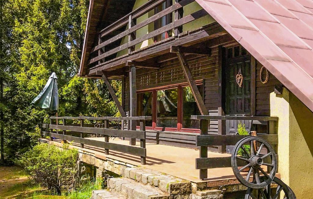 a wooden house with a porch and an umbrella at 3 Bedroom Beautiful Home In Studzienice in Studzienice