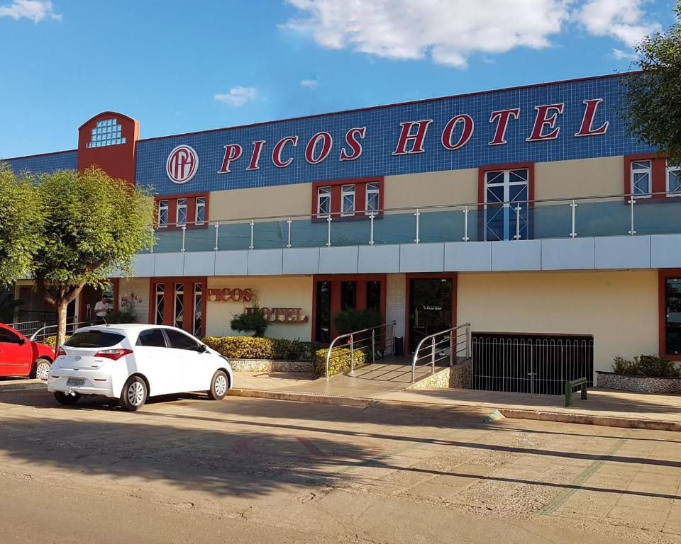 un'auto bianca parcheggiata davanti a un hotel Ricos di Picos Hotel a Picos