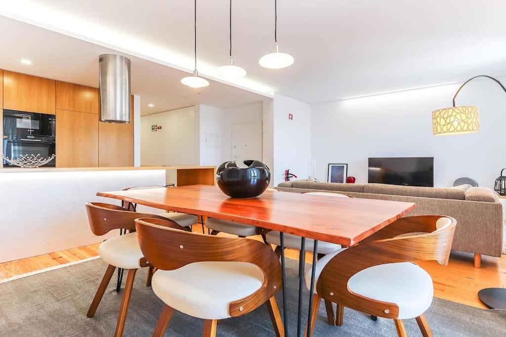 a kitchen and dining room with a wooden table and chairs at Outstanding Santos Spacious 2 Bedroom Apt w AC in Lisbon