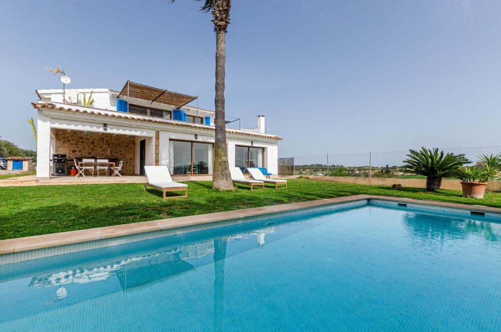 une villa avec une piscine en face d'une maison dans l'établissement YourHouse Carrera Plana, à Maria de la Salut