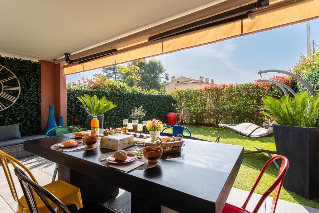d'une terrasse avec une table et de la nourriture. dans l'établissement DOMAINE DES ROSES 3 AP4400 By Riviera Holiday Home, à Nice