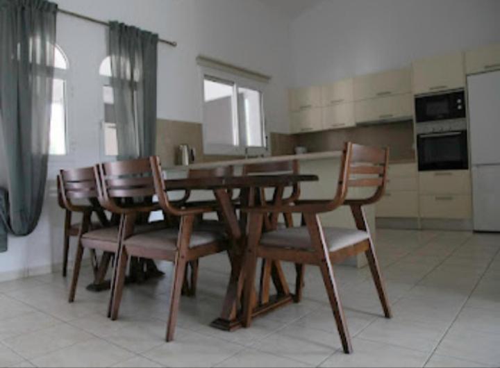 uma mesa de madeira e cadeiras numa cozinha em Beautiful villa five minutes from Coral Bay beach! em Coral Bay