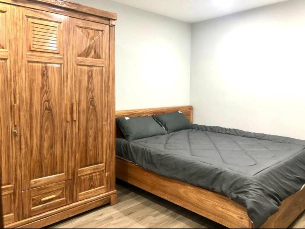 una camera da letto con un letto e un armadio in legno di Rental Apartment - LEVUHOUSE a Nha Trang