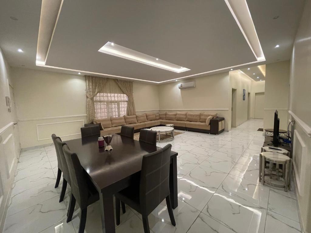 شقه غرفتين نوم وصاله ومجلس ومطبخ في الرياض: غرفة معيشة مع طاولة وأريكة