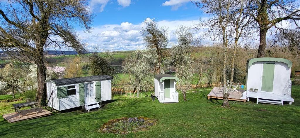 a group of three tiny houses in a field at Petit a Petit - gypsy wagons and Bell tents in the Bourgogne in Saisy