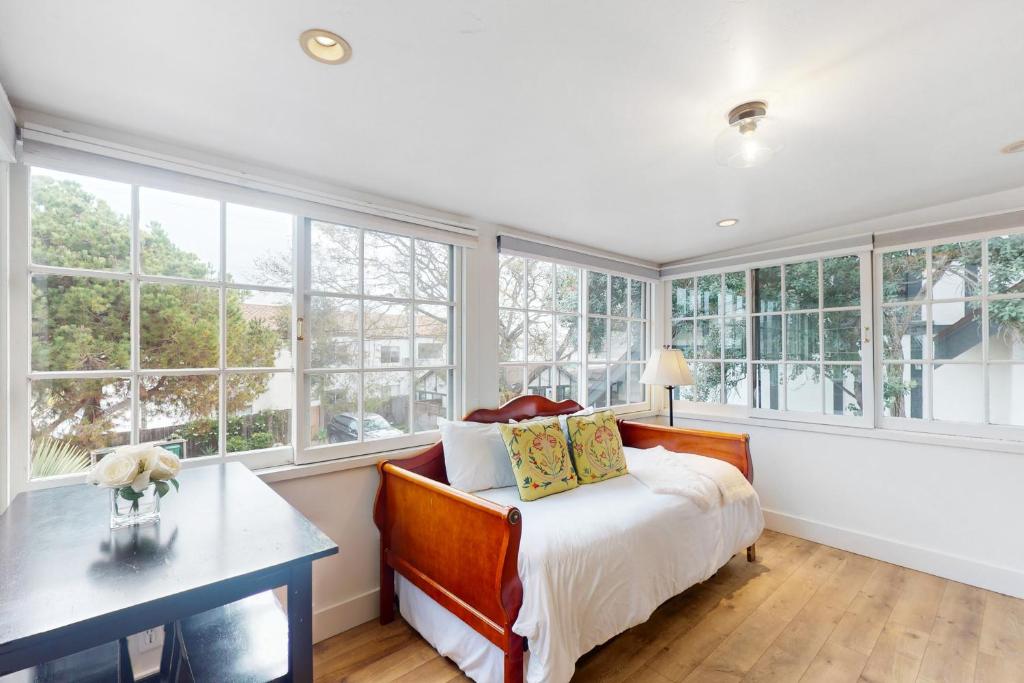 a bedroom with a bed and a desk and windows at Santa Cruz in Santa Barbara