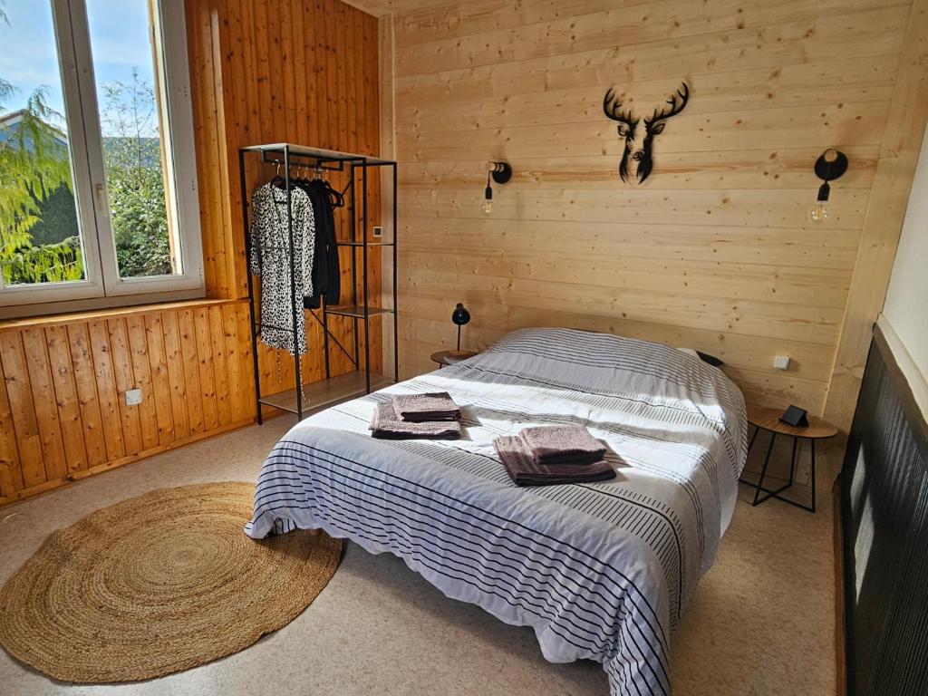 een slaapkamer met een bed in een houten kamer bij Appartement Chaleureux Gérardmer proche forêt in Gérardmer