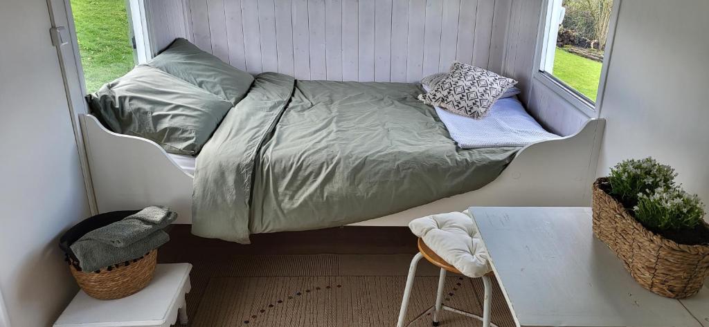a bed in a small room with a window at Petit a Petit - gypsy wagons and Bell tents in the Bourgogne in Saisy