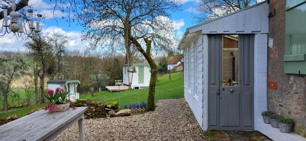a small shed with a bench in a yard at Petit a Petit - gypsy wagons and Bell tents in the Bourgogne in Saisy