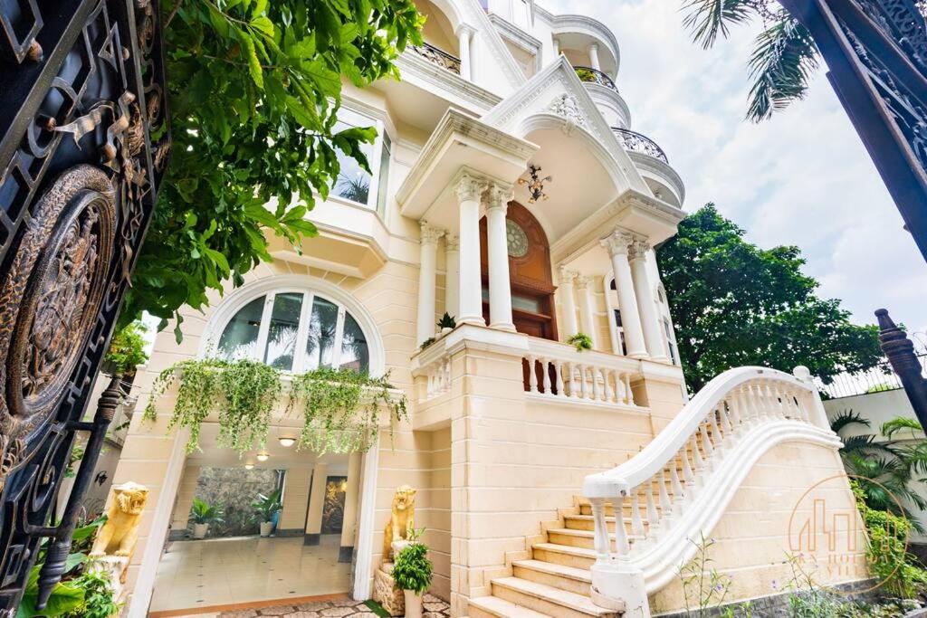 Un grand bâtiment blanc avec des escaliers se trouve juste devant. dans l'établissement KN1 HOLIDAY VILLA, à Hô-Chi-Minh-Ville