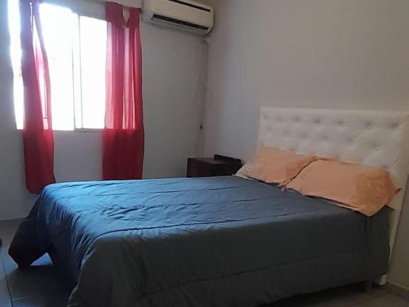 - une chambre avec un lit et une fenêtre avec des rideaux rouges dans l'établissement Cafaro, à San Miguel de Tucumán