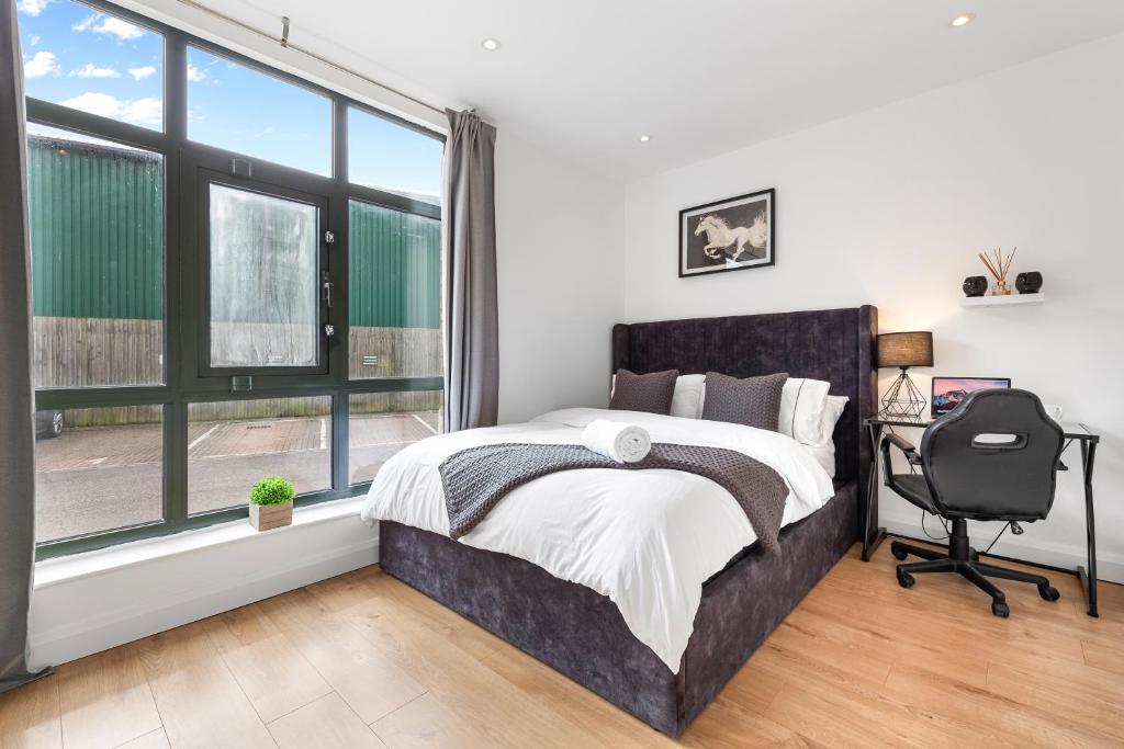 a bedroom with a bed and a desk and a window at Apartment in Hertfordshire in Hemel Hempstead