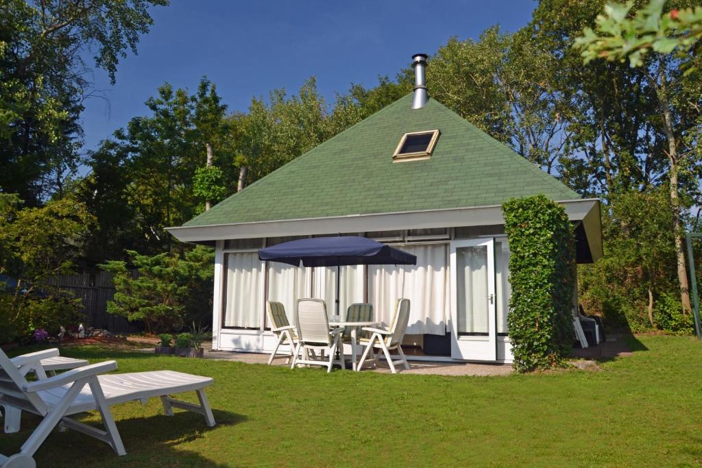 a white gazebo with chairs and an umbrella at Bungalowpark De Toekomst in Ouddorp